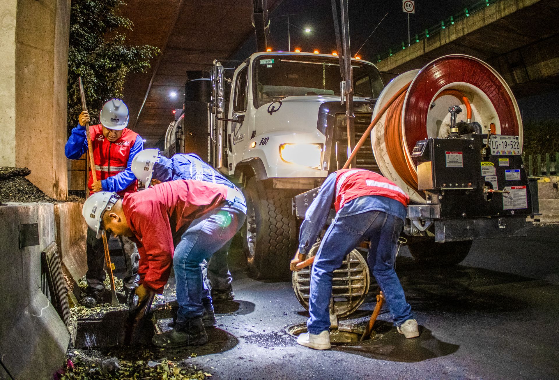 Équipe et camion hydrocureur en intervention de nuit sur un regard