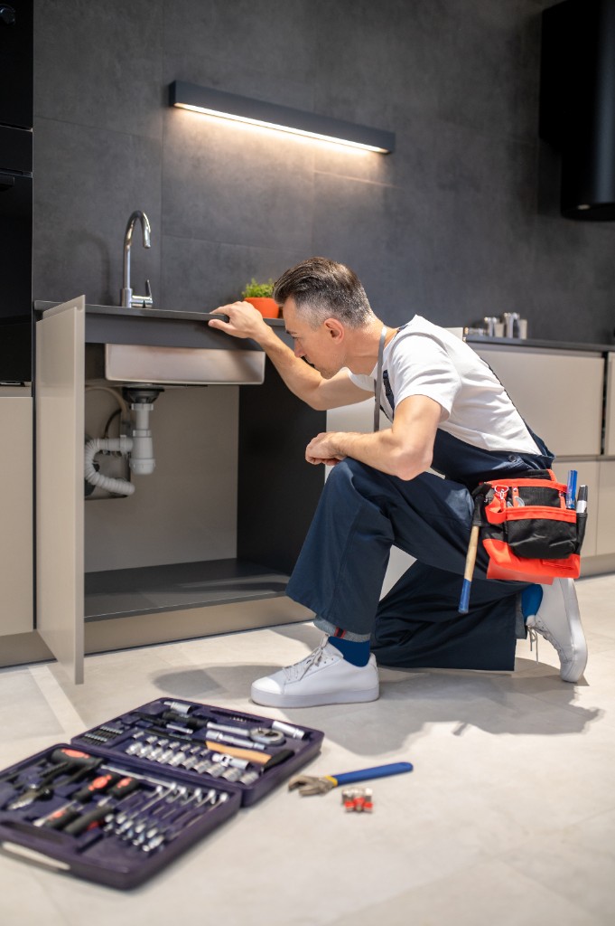 Plombier au travail — inspection des canalisations sous évier